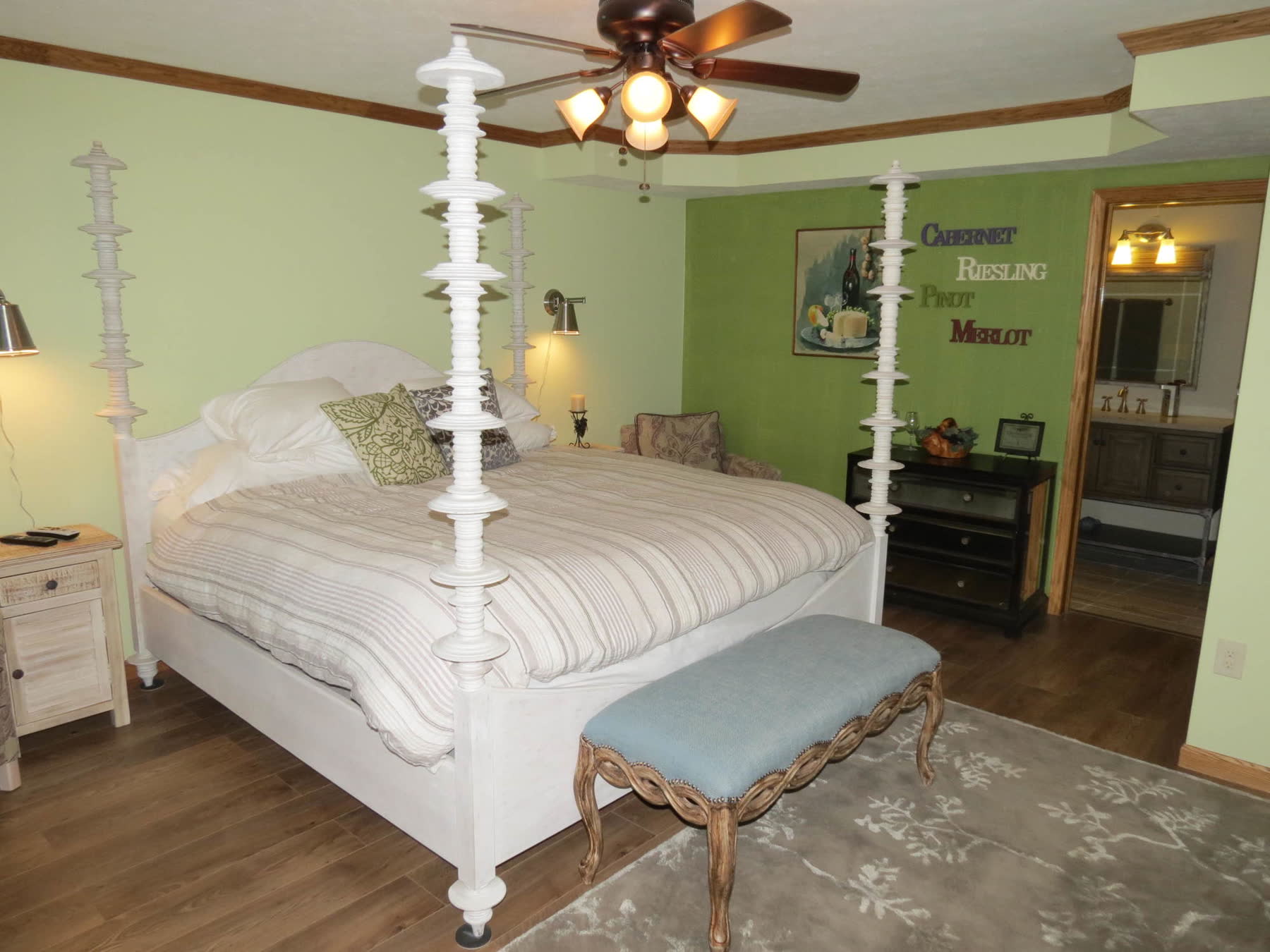 The Vineyard room, green walls and a white four-poster king bed