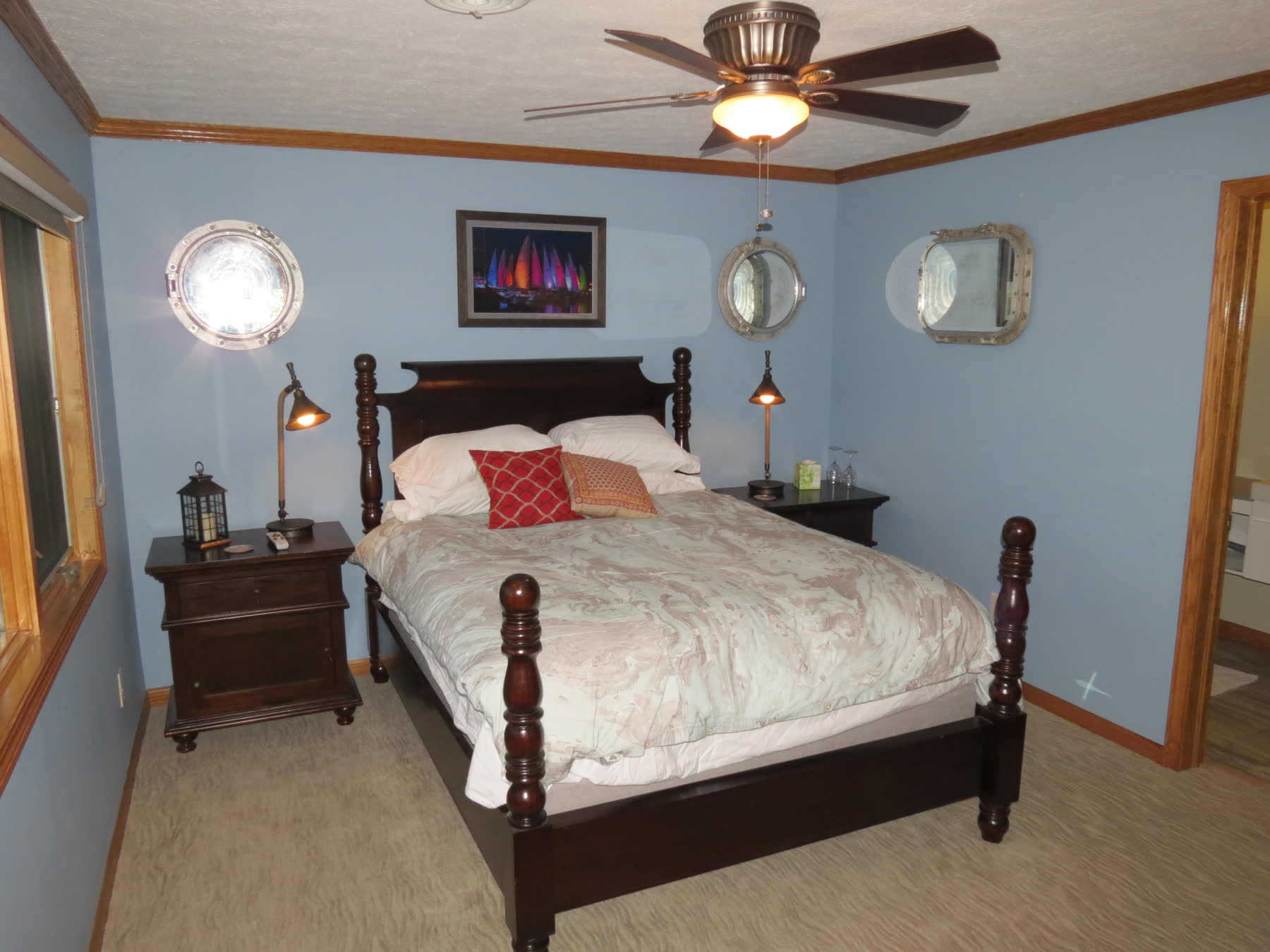 The Nautical room, pale blue with brass portholes above the bed